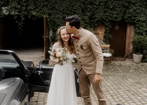 Hochzeitspaar an einem Cabrio