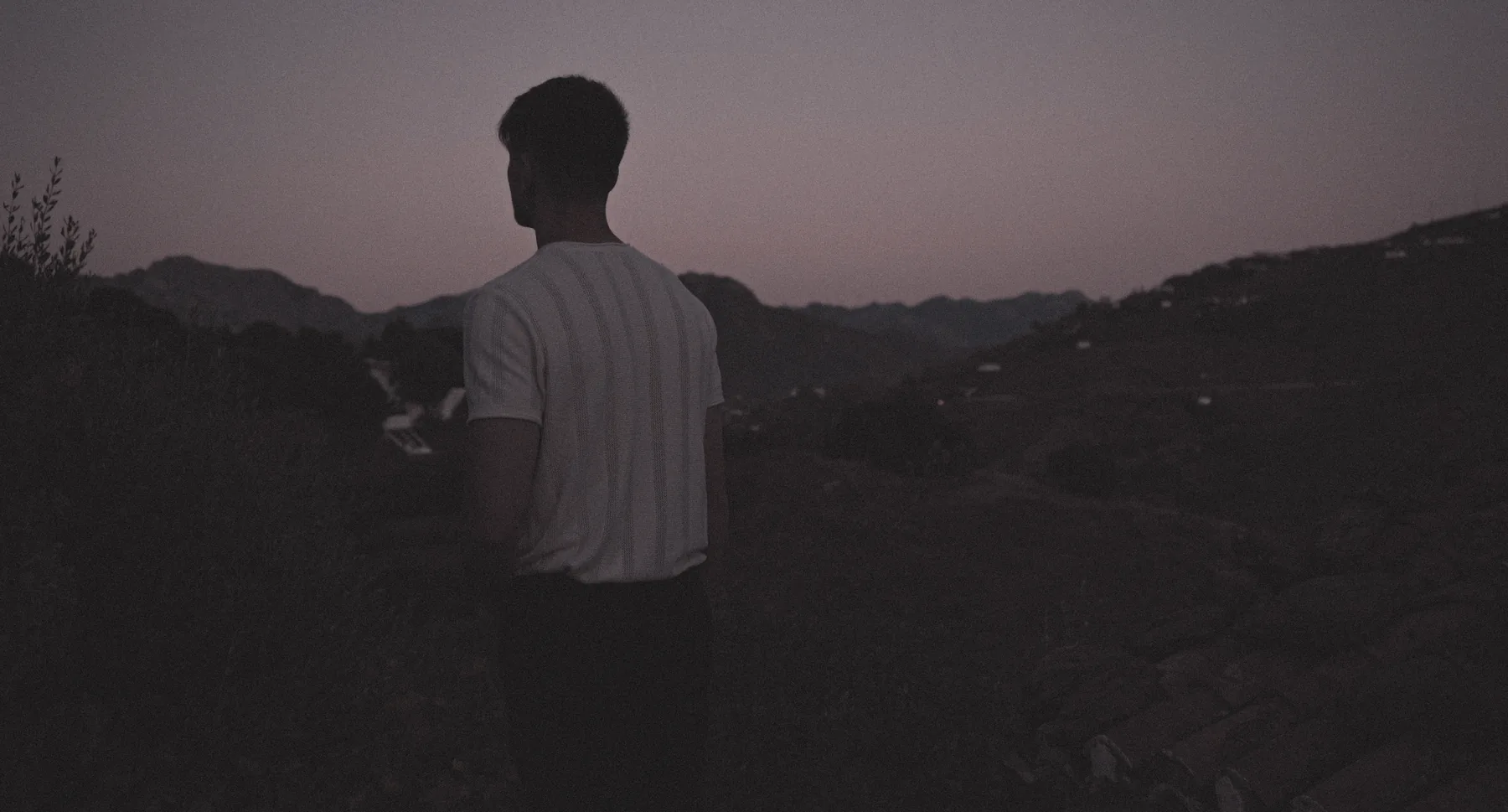 Florian blickt in der Dämmerung über eine Landschaft