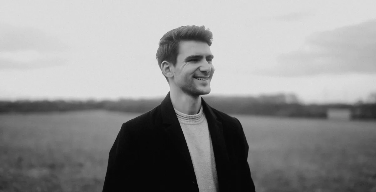 Florian Zimmermann lächelt in einer offenen Landschaft